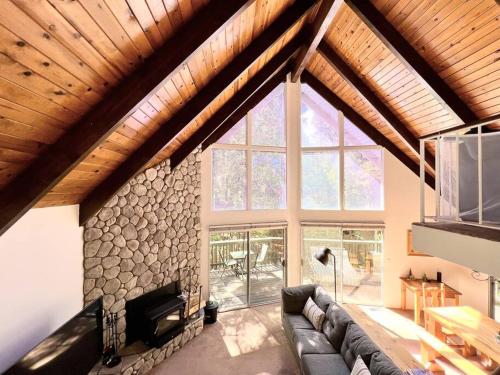 een woonkamer met een bank en een stenen muur bij Family Friendly A Frame, Pets stay Free! in Lake Arrowhead