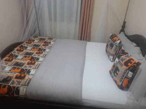ein Bett mit einer Bettdecke und Kissen darauf in der Unterkunft Starnford Hotel in Njara