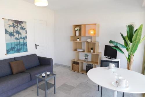 a living room with a couch and a table at Charming T2 Eden Park with swimming pool private parking in Juan-les-Pins