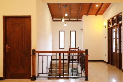 Cette chambre est dotée d'un escalier et d'une porte en bois. dans l'établissement Iconic Villa, à Ahangama