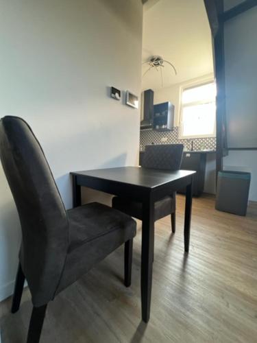 a black chair and a table and a chair and a room at MyCityLofts in Rotterdam