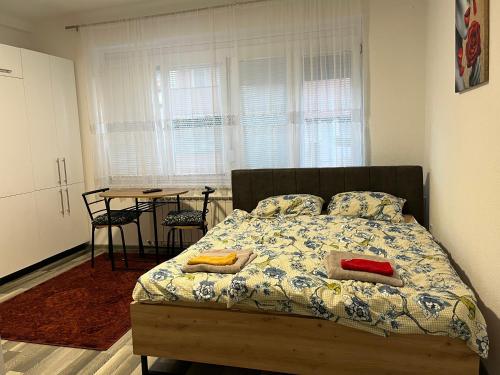a bedroom with a bed with two pillows and a table at Stan na dan, Pazar Tuzla - centar grada in Tuzla