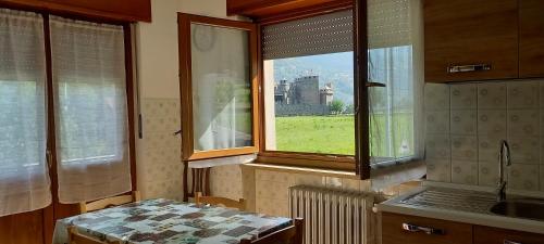 cocina con ventana, fregadero y mesa en Vue du Chateau en Fenis