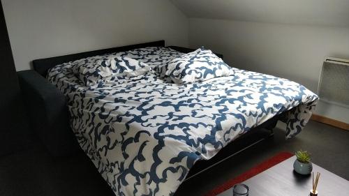 - un lit avec une couverture et des oreillers bleus et blancs dans l'établissement Studio proche centre-ville et gare, à Amiens