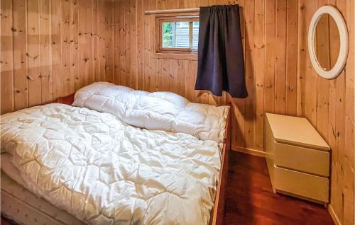 uma cama num quarto de madeira com uma janela em Nice Home In Sagstua With Lake View 