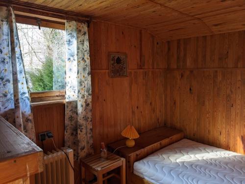 a small bedroom with a bed and a window at Domek wakacyjny Lachertówka Ostrów Wielki in Gil Mały