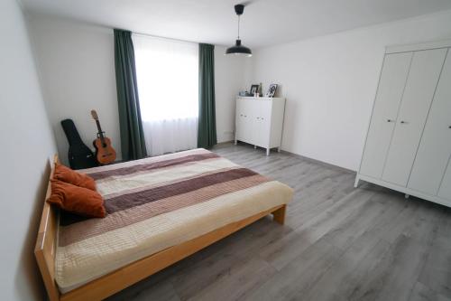 a bedroom with a bed and a guitar in it at Vila Puha in Vrakúň