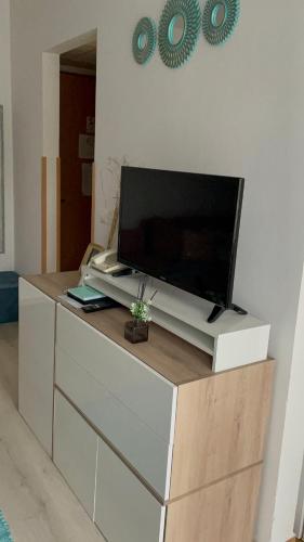 a flat screen tv sitting on top of a dresser at Joy Apartman in Zalakaros