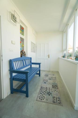 a blue bench sitting in a room with a rug at Vila Puha in Vrakúň