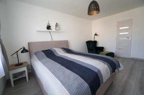 Vila Puha في Vrakúň: غرفة نوم بسرير وبطانية مخططة باللون الأزرق والأبيض