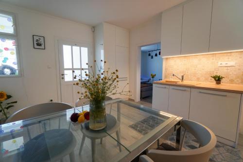 a kitchen with a glass table with a vase of flowers on it at Vila Puha in Vrakúň