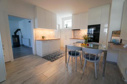 a kitchen with a table and some chairs in it at Vila Puha in Vrakúň