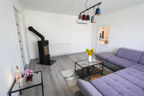 a living room with a purple couch and a fireplace at Vila Puha in Vrakúň