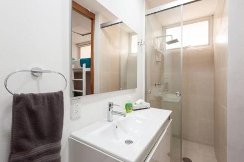 y baño blanco con lavabo y ducha. en Mi casa, en la zona más exclusiva de México, en Ciudad de México