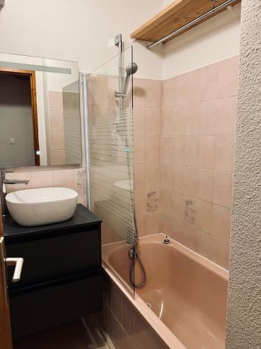 une salle de bain avec un lavabo, une douche et une baignoire dans l'établissement Serre Chevalier, appartement T3, 4 personnes plein sud avec balcon, près des pistes, Meublé touristique 3 étoiles, à La Salle Les Alpes