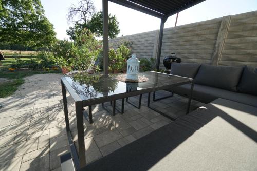 a glass table and a couch on a patio at Vila Puha in Vrakúň