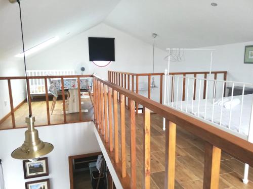 a living room with a staircase and a flat screen tv at Casa da Canada da Fajã in Feteira