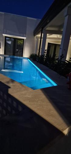 a swimming pool in front of a house at night at Thalassa Rooms in Avola
