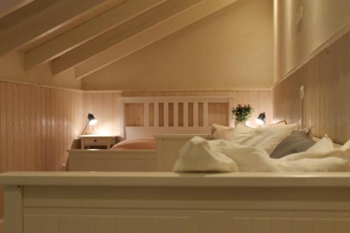 a bedroom with a bed with white sheets and pillows at Die Hofraite Flonheim in Flonheim