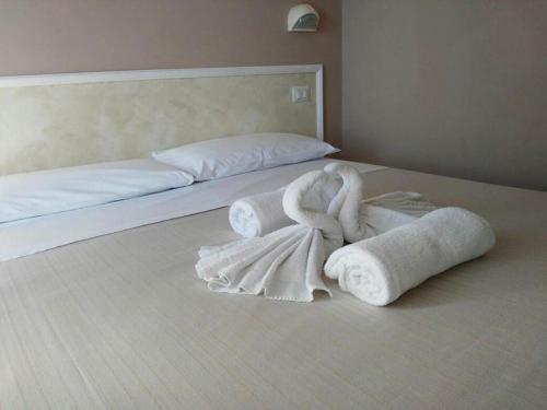 Una cama con toallas encima. en Hotel Villa Mon Reve, en Rímini