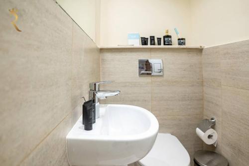 Łazienka z białą toaletą i umywalką w obiekcie Blackforest 2BR Duplex at Masdar Oasis w Abu Zabi