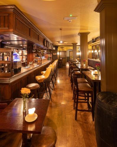 a restaurant with wooden tables and chairs and a bar at McGettigan's Townhouse - Olives & Figs Bistro in Dublin
