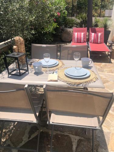 una mesa con dos sillas y platos en ella en Maison d'hôtes Antoinette, en Cogolin