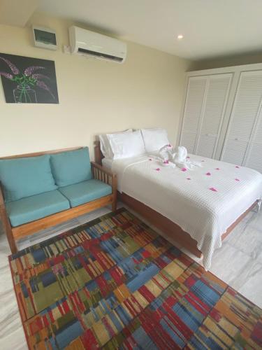 a bedroom with two beds and a couch and a rug at Memwa Villas in Castries