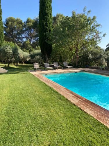 - une piscine dans une cour avec des chaises et des arbres dans l'établissement La Manuia, à Ventabren