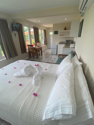 sypialnia z białym łóżkiem z różowymi płatkami róży w obiekcie Memwa Villas w mieście Castries