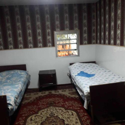 a small room with two beds and a window at Norik's Beach Rest Cottages in Sevan