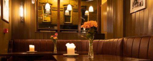 two vases with flowers and candles on a table at McGettigan's Townhouse - Olives & Figs Bistro in Dublin