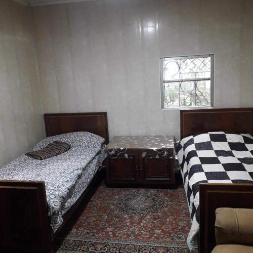 two beds in a room with a window at Norik's Beach Rest Cottages in Sevan