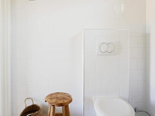 a bathroom with a tub and a toilet and a stool at Modern Beach Cottage in Tofta, Gotland in Gnisvärd