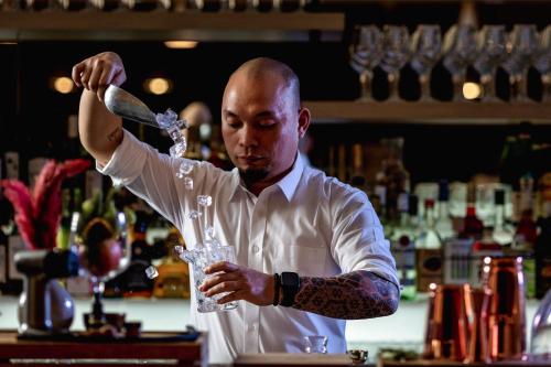 a man in a bar stirring a drink at Holiday Inn & Suites - Dubai Science Park by IHG in Dubai
