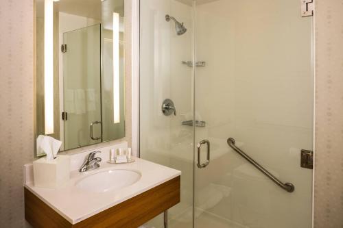 y baño con lavabo y ducha. en SpringHill Suites by Marriott New York LaGuardia Airport en Queens