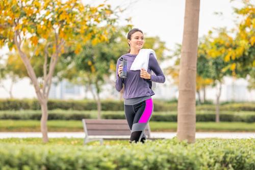 a woman is running in a park at Holiday Inn & Suites - Dubai Science Park by IHG in Dubai