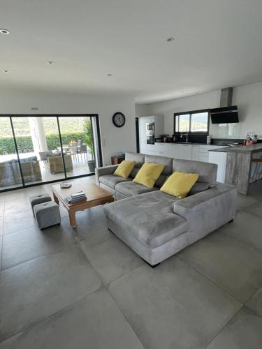 ein Wohnzimmer mit einer grauen Couch und gelben Kissen in der Unterkunft VILLA Azura 5 étoiles Vue panoramique in Sainte-Maxime