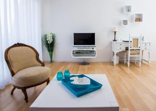 sala de estar con silla, mesa y TV en Apartment Bloo Suite, en Split