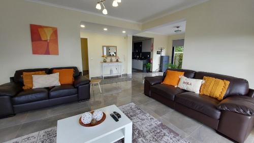 een woonkamer met 2 banken en een tafel bij Villa Strelitzia in Funchal