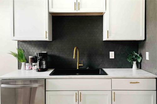 a kitchen with white cabinets and a sink at Leaning House of Haynie in Evansville