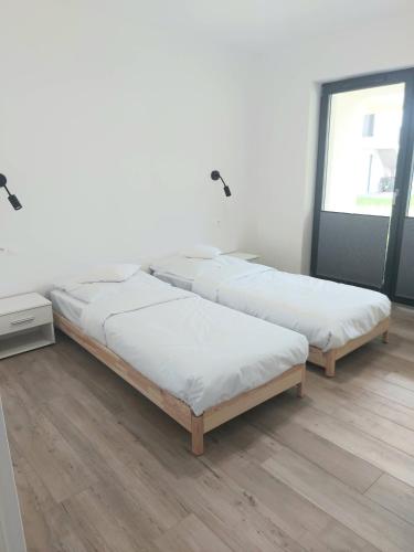 a row of beds in a room with wooden floors at Apartament na Osiedlu Zielone Zarabie in Myślenice