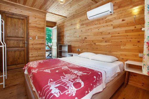 1 dormitorio con 1 cama en una pared de madera en Chakra Beach Kabak en Faralya