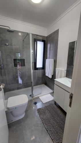 a bathroom with a toilet and a sink and a shower at Villa Strelitzia in Funchal