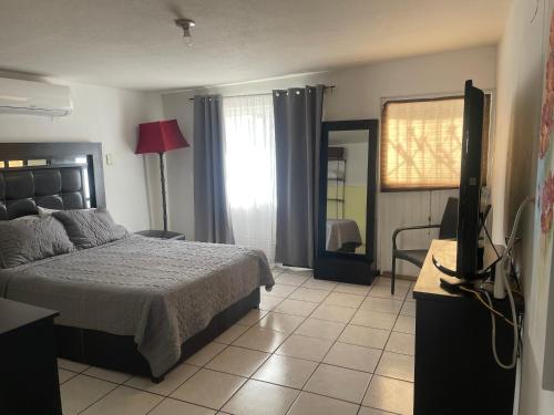 ein Schlafzimmer mit einem Bett und einem TV in der Unterkunft Departamento privado con cochera y WIFI alta velocidad in Chihuahua