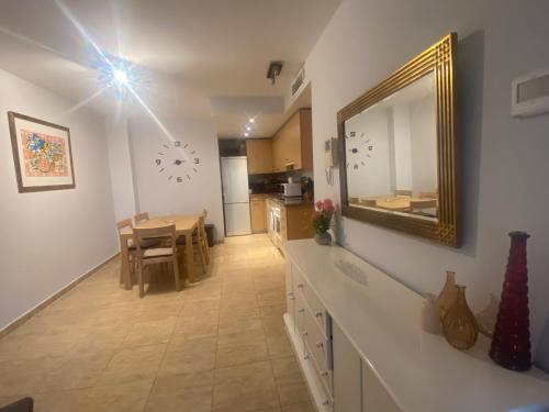 Una cocina y un comedor con un espejo y una mesa. en Apartamento Julieta, en Estepona