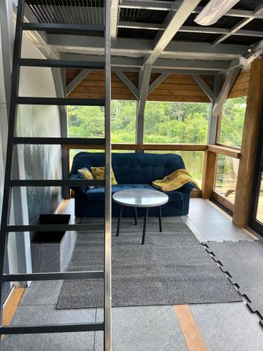 a living room with a blue couch and a table at Domek Survivalowy w Spale in Spała