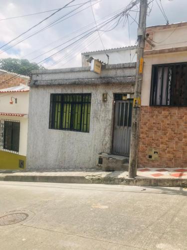 un edificio con ventanas verdes en el lateral de una calle en hostal la 18, en Pereira