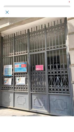 a metal gate with signs on it in a building at Aparthotel Old Avenue in Tbilisi City