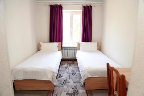 two beds in a room with a window at Hotel Good Night in Jalal-Abad